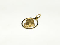 In the center: a framed profile of a blindfolded Lady Justice medallion style pendant in 14 karat yellow gold laying flat facing upalternate angle made by Popular Jewelry in New York City