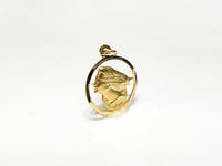 In the center: a framed profile of a blindfolded Lady Justice medallion style pendant in 14 karat yellow gold standing up facing vieweralternate angle made by Popular Jewelry in New York City