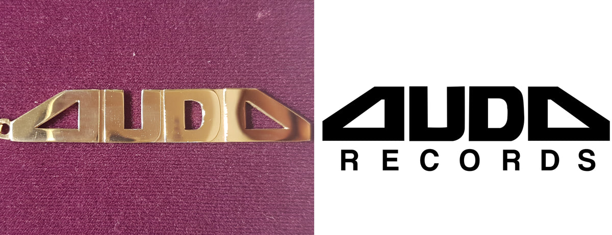 In the center: a custom made 14 karat yellow gold name plate made for Auda Records in high polish finish by Popular Jewelry in New York City
