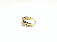 In the center: 10 karat yellow gold lady's puffy round link ring set with cubic zirconia in micro pave setting laying on its side with its left side facing the viewer made by Popular Jewelry