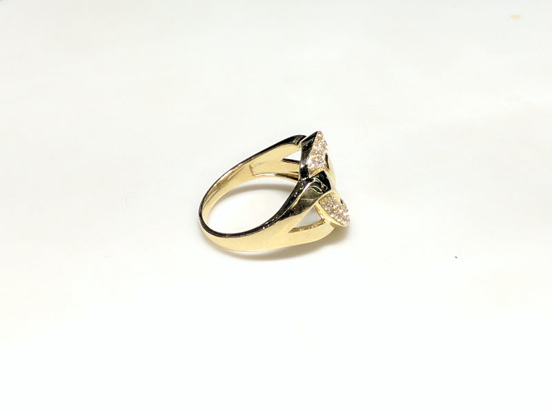In the center: a 10 karat yellow gold lady's ring in the shape of a flat round link set with cubic zirconia in a micro pave setting laying on its side with its right side facing viewer made by Popular Jewelry in New York City