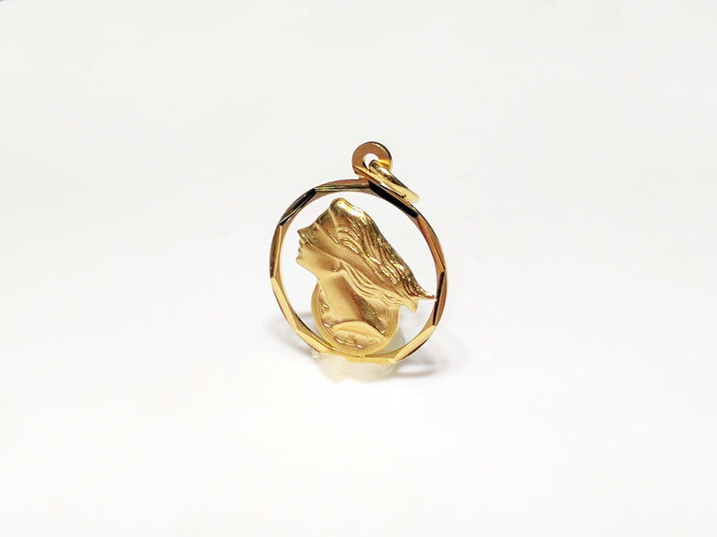 In the center: a framed profile of a blindfolded Lady Justice medallion style pendant in 14 karat yellow gold standing up facing viewerangle made by Popular Jewelry in New York City