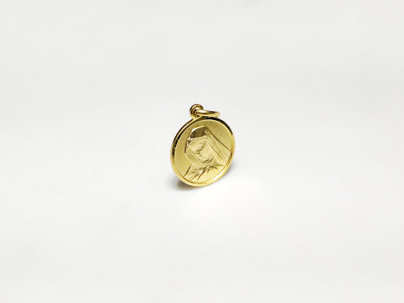 In the center: a portrait of Mary looking downher son Jesus in a 14 karat yellow gold medallion style pendant standing up facing vieweralternate angle made by Popular Jewelry in New York City