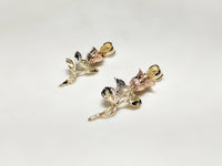С лијева на десно: мали (36 мм) и велики (42.5 мм) дугачак, привјесак за ружу у злату од 14 карата, а латице руже злата постављају кут гледања према гледаоцу Popular Jewelry у Нев Иорку