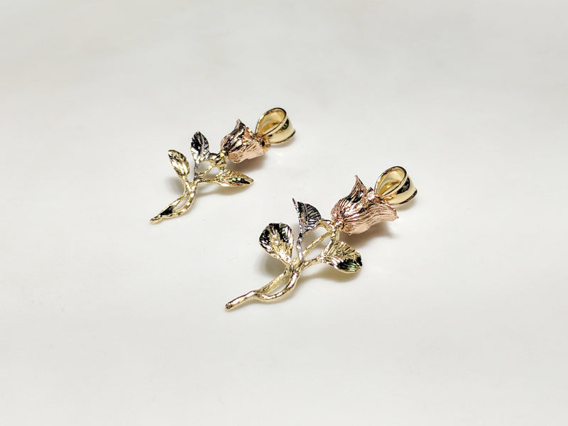 From left to right: a small (36 mm) and large (42.5 mm) long stemmed rose pendant in 14 karat gold with rose gold petals laying flatan angle to viewer made by Popular Jewelry in New York City