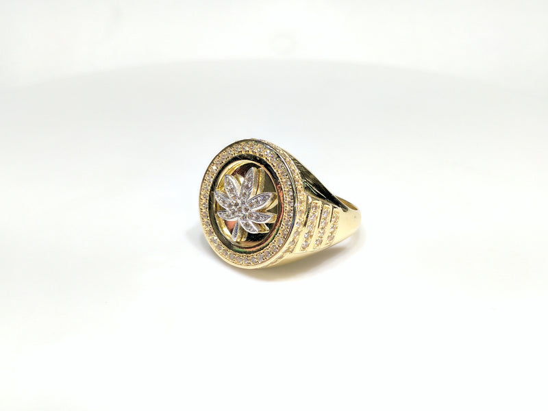 45 angle view of a 10 karat yellow gold signet ring with a white marijuana leaf embedded inside a bezel iced out with cubic zirconia - Popular Jewelry New York