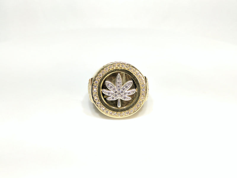 Front view of a 10 karat yellow gold signet ring with a white marijuana leaf embedded inside a bezel iced out with cubic zirconia - Popular Jewelry New York