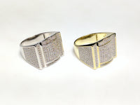 From left to right: white and yellow sterling silver men's rings set with cubic zirconia in a micro pave setting laying side by sideangle view made by Popular Jewelry in New York City