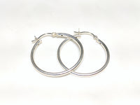 A pair of sterling silver hoop earrings in plain high polished finished stacked and laying flat Popular Jewelry