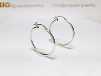 A pair of sterling silver hoop earrings in high polished finish standingan angle - Popular Jewelry